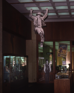 Life-sized John Wayne cut-out leaps into the center of my &ldquo;Western Film&rdquo; exhibit, UT Austin, 1991.